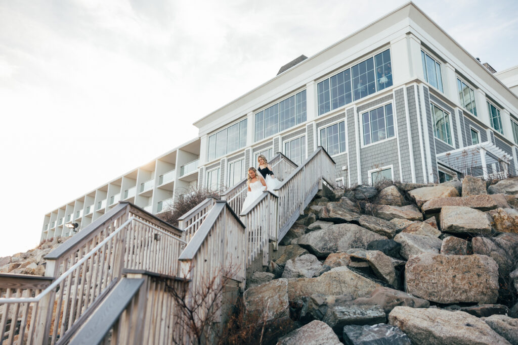 Bride coming down the stairs for a first lok at the Cliff House in Cape Neddick, Maine